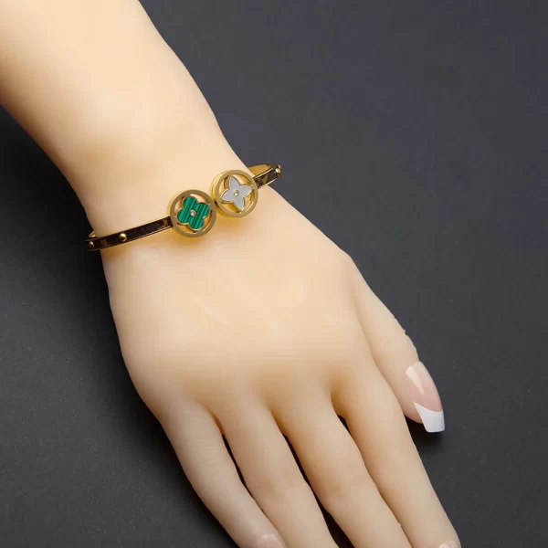 Golden bangle inlaid with leather with shell and green stones